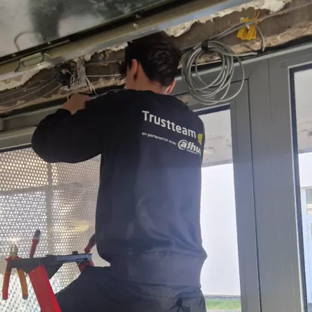 technicien Trustteam en intervention en train de raccorder des câbles 